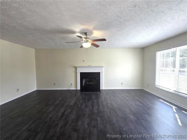 an empty room with fan and windows