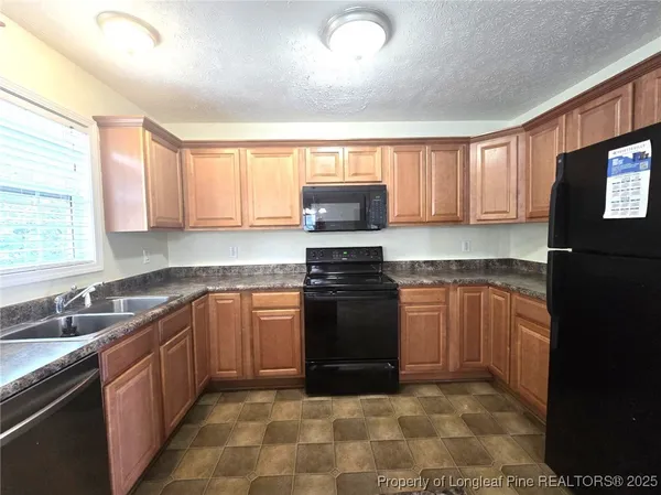 a kitchen with stainless steel appliances granite countertop a stove sink and cabinets