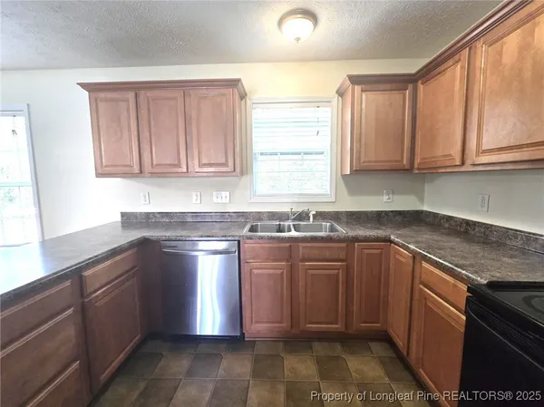 a kitchen with stainless steel appliances granite countertop a sink stove and cabinets