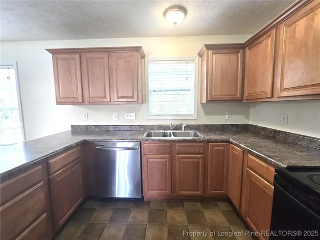 a kitchen with stainless steel appliances granite countertop a sink stove and cabinets