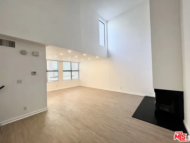 an empty room with wooden floor and cabinet