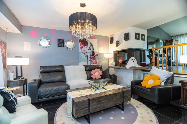 a living room with fireplace furniture and a chandelier