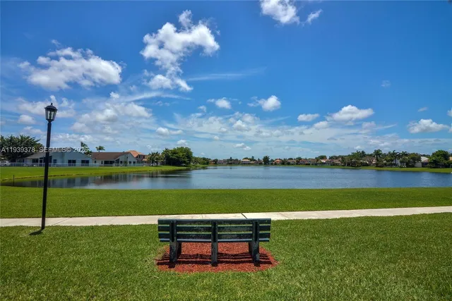 a view of a lake with a yard and a large tree