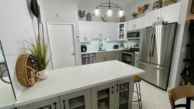 a kitchen with stainless steel appliances a table chairs refrigerator and stove