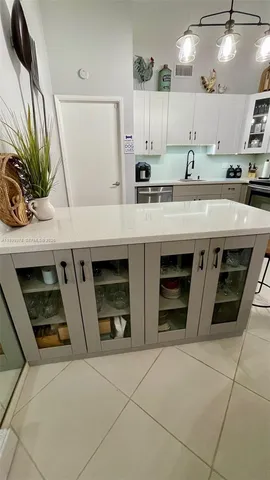 a kitchen with stainless steel appliances a sink a stove a refrigerator and cabinets