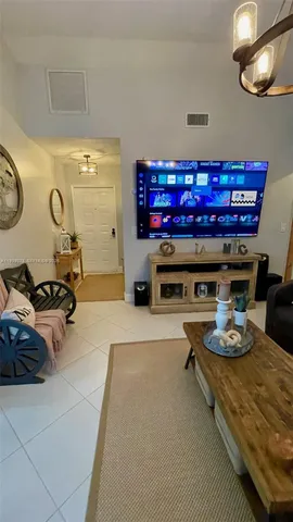 a living room with furniture a flat screen tv and a wall clock