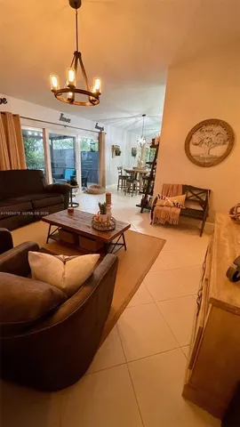 a living room with furniture a chandelier and a flat screen tv