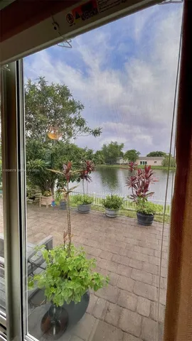 a view of a lake with a big yard and potted plants
