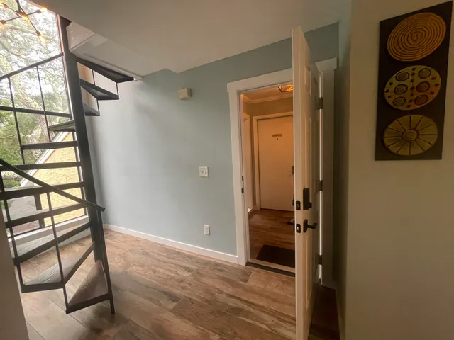 a view of hallway with wooden floor and furniture