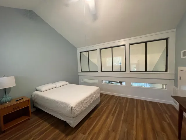 a bedroom with a bed and a large window
