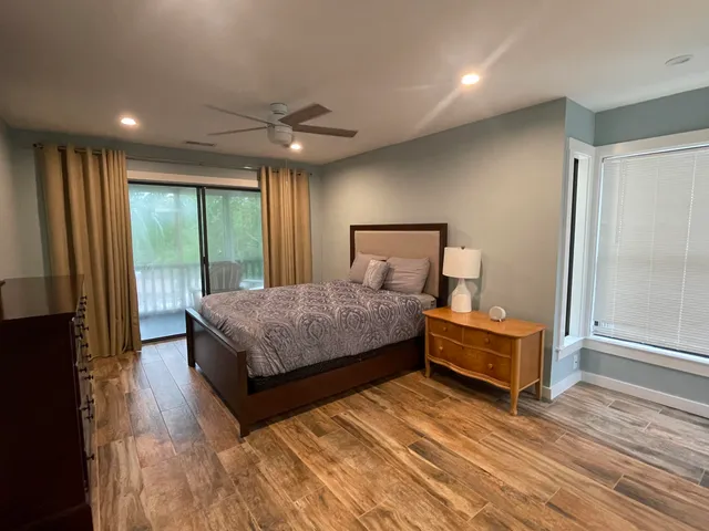 a bedroom with a bed wooden floor and window