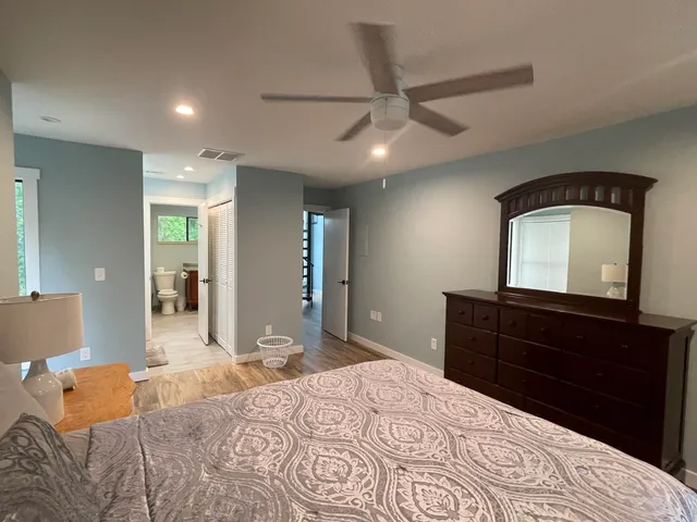 a bedroom with a bed and a mirror on dresser