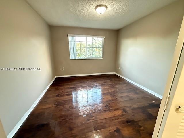 4167 Haverhill Road, Unit 1113 West Palm Beach, FL 33417 - Photo 11 of 19 an empty room with wooden floor and windows