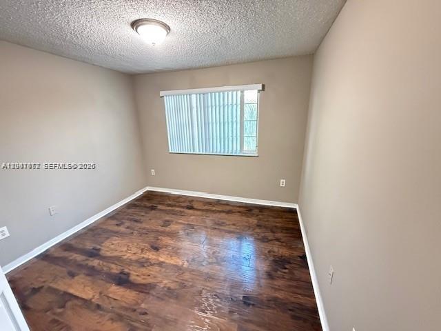 4167 Haverhill Road, Unit 1113 West Palm Beach, FL 33417 - Photo 13 of 19 an empty room with wooden floor and windows