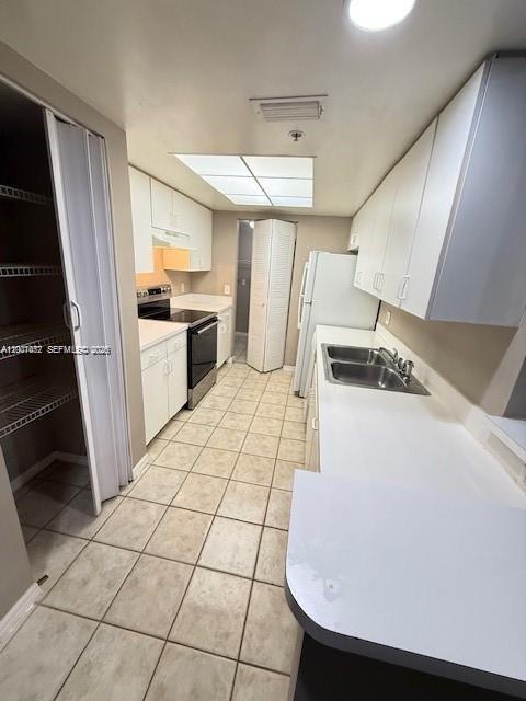 4167 Haverhill Road, Unit 1113 West Palm Beach, FL 33417 - Photo 8 of 19 a kitchen with a sink a stove top oven and cabinets