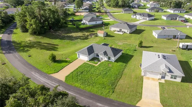 an aerial view of a house with a garden and lake view