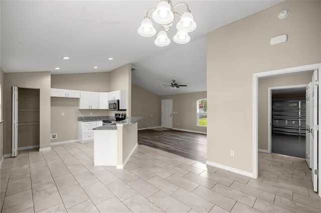 a kitchen with stainless steel appliances kitchen island granite countertop a refrigerator and a stove top oven