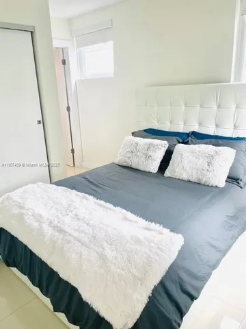 a bed sitting in a bedroom next to a window