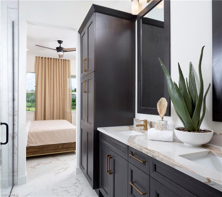 7164 Cayo Coco Lane Naples, FL 34113 - Photo 7 of 19 a bathroom with a double vanity sink a mirror and a shower