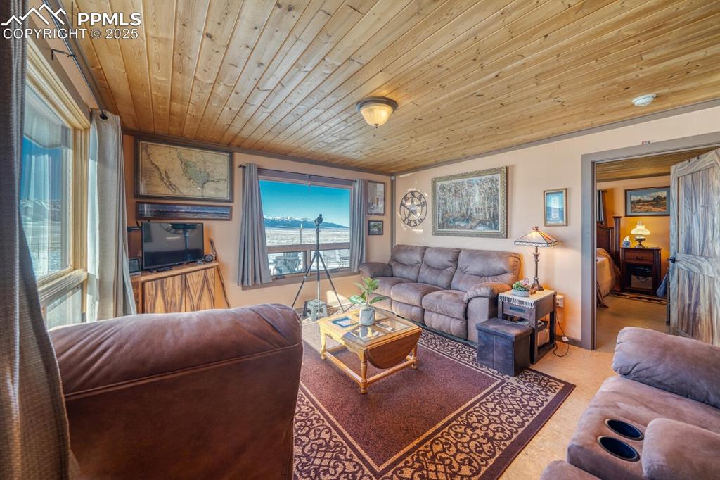 565 Pass Peak Road Westcliffe, CO 81252 - Photo 3 of 50 a living room with furniture a flat screen tv and a large window