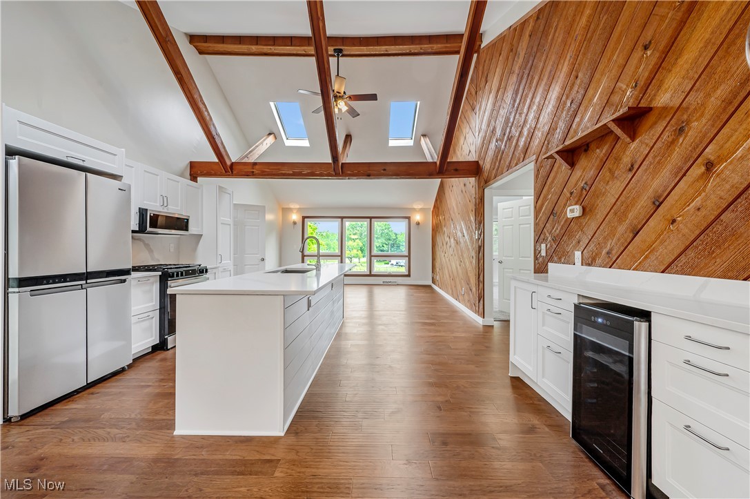 12358 Harmon Road New Springfield, OH 44443 - Photo 6 of 44 Kitchen featuring white cabinetry, high vaulted ceiling, stainless steel appliances, beam ceiling, and wine cooler