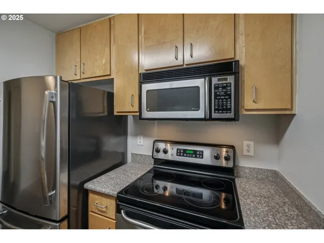 a kitchen with stainless steel appliances granite countertop a stove microwave and refrigerator