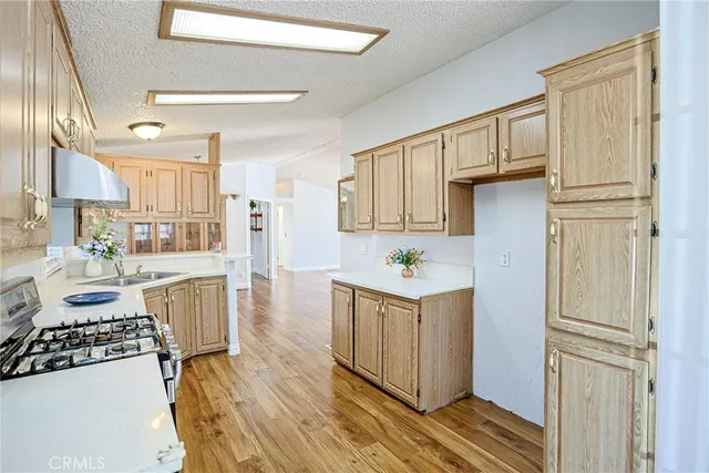 a kitchen with a refrigerator a stove cabinets and wooden floor