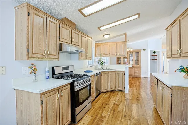 a kitchen with granite countertop a sink cabinets stainless steel appliances and a counter space