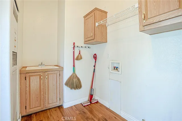 an empty room with wooden floor chandelier fan and windows