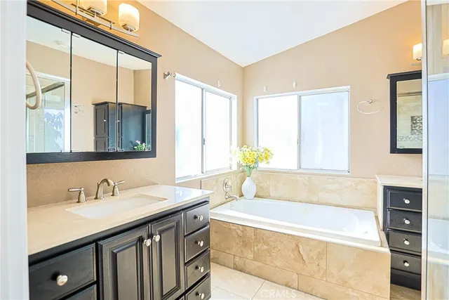 a spacious bathroom with a granite countertop tub sink and mirror