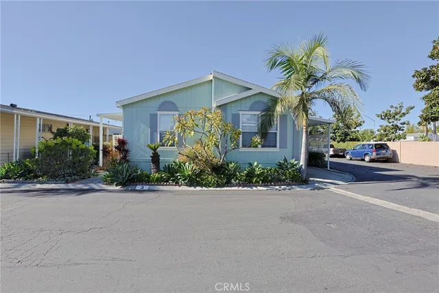 a view of a house with a yard and potted plants