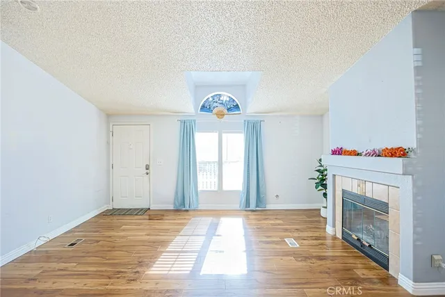 a view of an empty room with a fireplace and a window