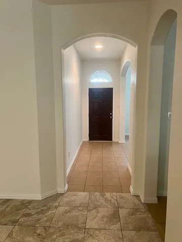 a view of a hallway with wooden floor and a mirror