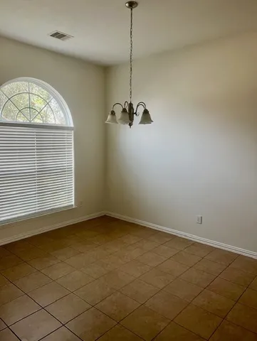a view of a room with a large window and chandelier