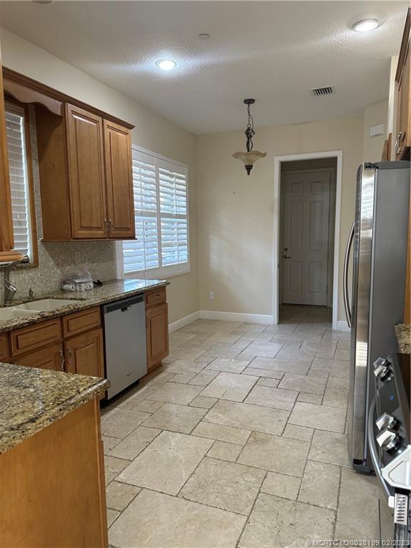 270 Southwest Walking Path Stuart, FL 34997 - Photo 7 of 25 a kitchen with granite countertop a stove a sink and a refrigerator