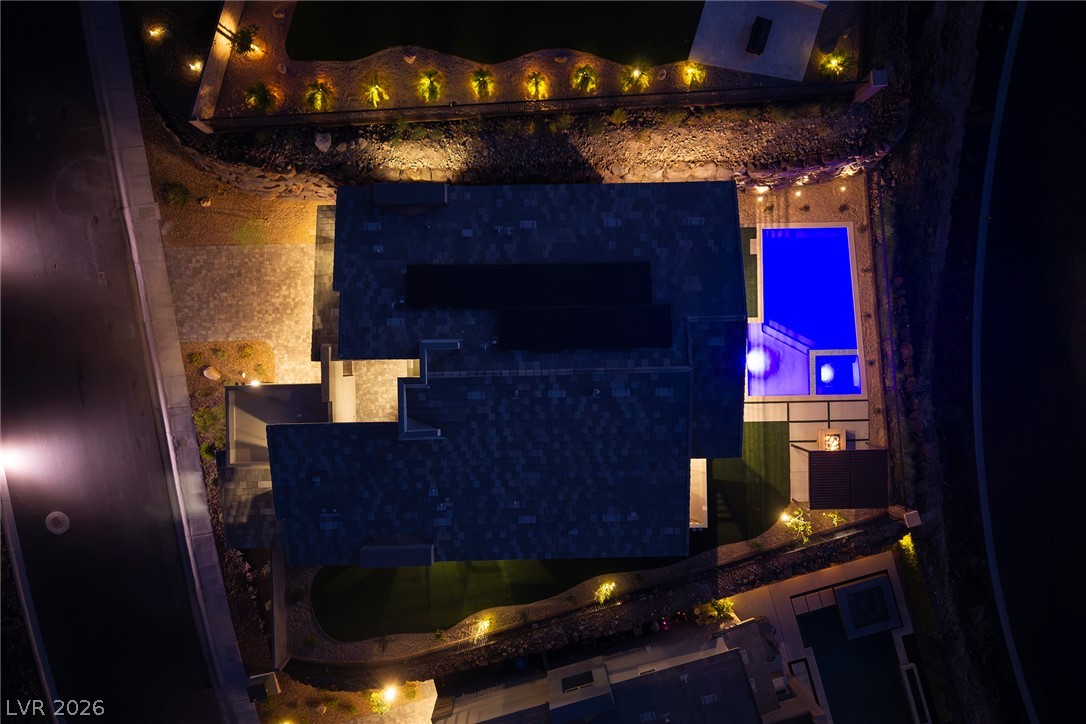 526 Riley Ridge Henderson, NV 89012 - Photo 8 of 10 An aerial nighttime view showcases a property with illuminated landscaping, a private pool, and modern architecture.
