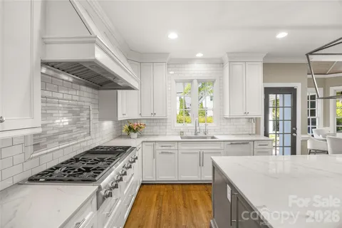 a kitchen with stainless steel appliances granite countertop sink stove and cabinets