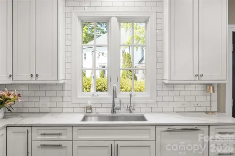 a kitchen with stainless steel appliances white cabinets and a window
