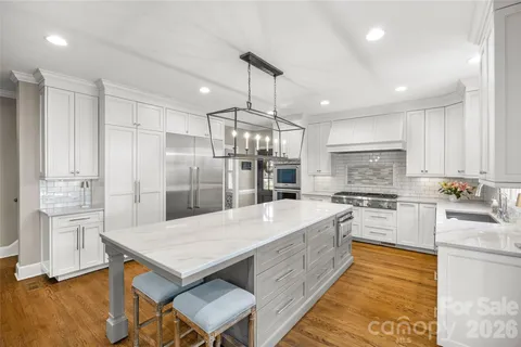 a large kitchen with kitchen island a large counter top space appliances and cabinets