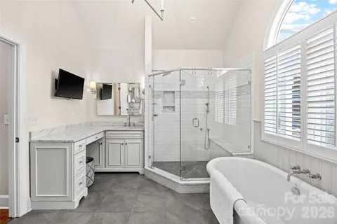 a spacious bathroom with a granite countertop tub sink a mirror and shower