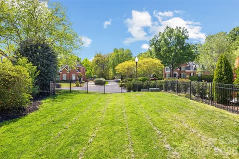 a backyard of a house with lots of green space and fountain