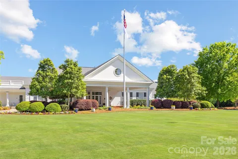 a front view of a house with a garden and trees