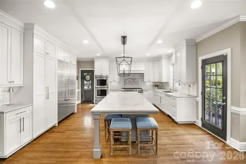 a large kitchen with kitchen island a large island a sink stainless steel appliances and cabinets