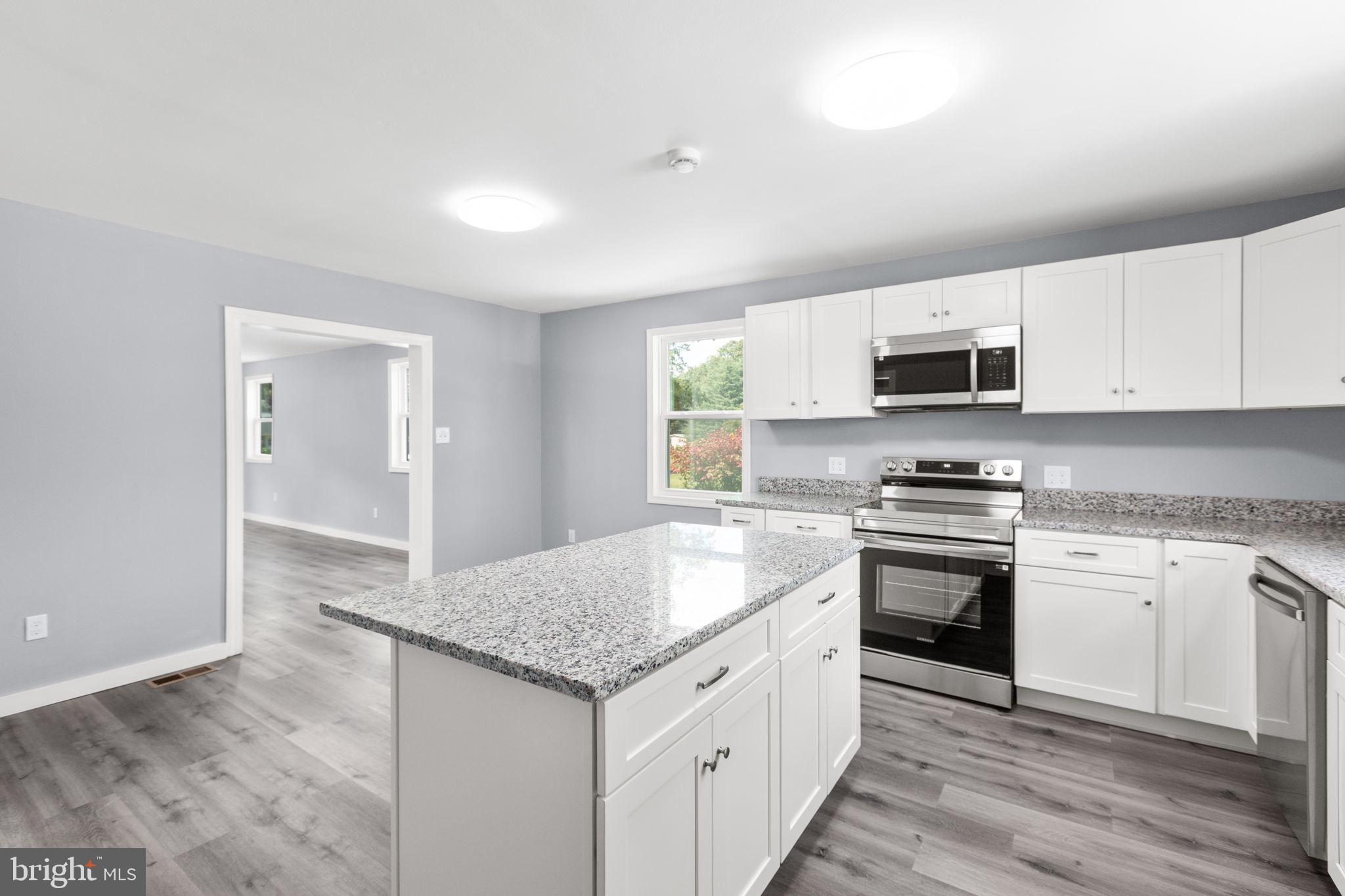 9113 Thornton Rolling Road Fredericksburg, VA 22408 - Photo 13 of 31 a kitchen with stainless steel appliances granite countertop a sink stove microwave and cabinets