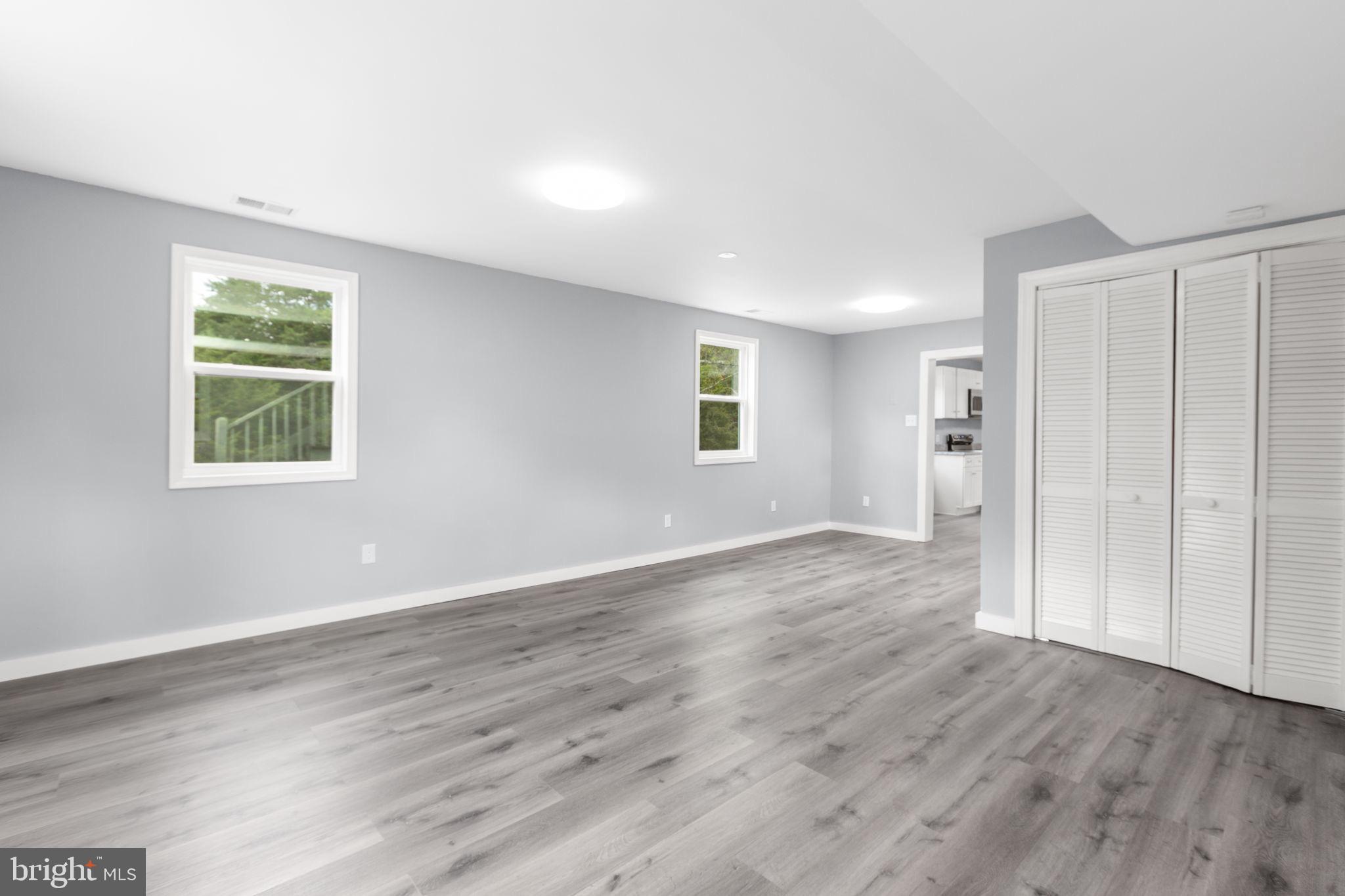 9113 Thornton Rolling Road Fredericksburg, VA 22408 - Photo 17 of 31 an empty room with wooden floor and windows