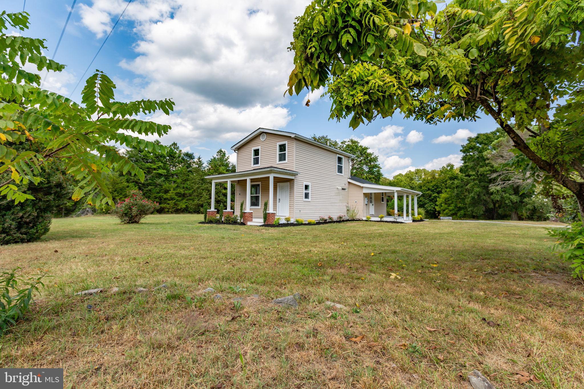 9113 Thornton Rolling Road Fredericksburg, VA 22408 - Photo 2 of 31 a front view of a house with a garden
