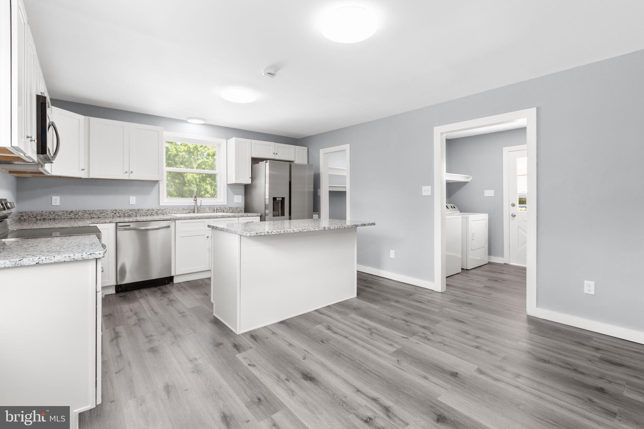 9113 Thornton Rolling Road Fredericksburg, VA 22408 - Photo 6 of 31 a kitchen with a sink cabinets and wooden floor