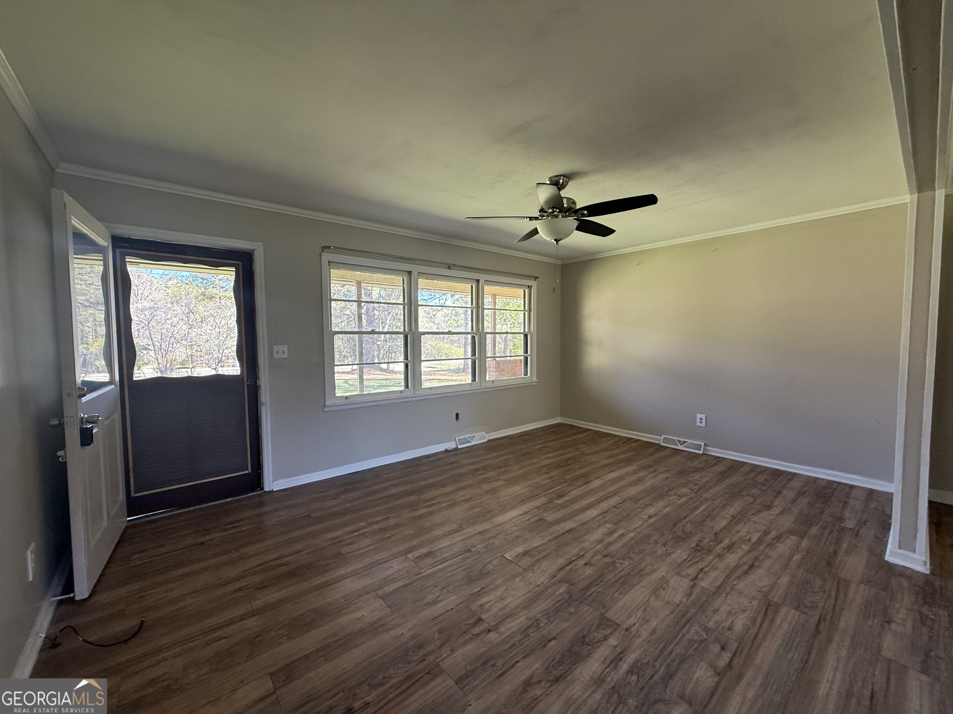 28 Brewer Road Jewell, GA 31045 - Photo 2 of 27 an empty room with wooden floor fan and windows