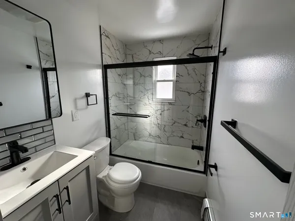 a bathroom with a shower toilet and sink