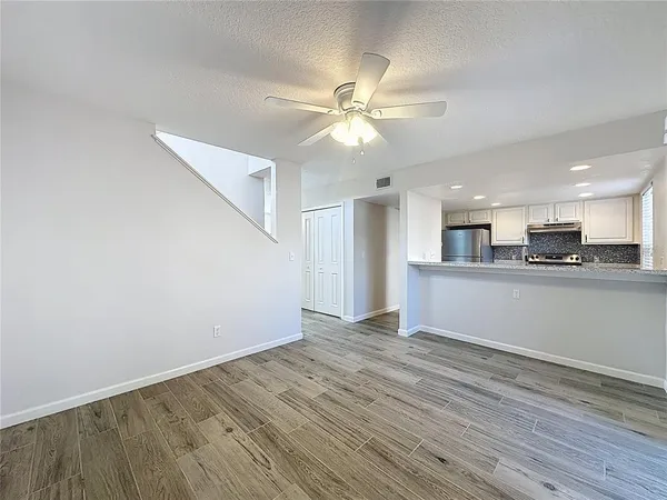 a view of a kitchen with a fridge wooden floor and a kitchen
